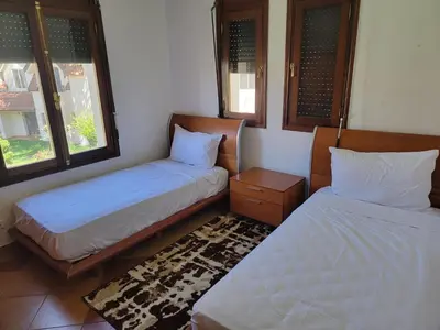 two beds in a room with two windows at Chalet Haut standing pour les familles seulement in Ifrane