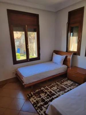a bedroom with two beds and two windows at Chalet Haut standing pour les familles seulement in Ifrane