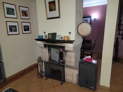 a living room with a fireplace and a chair at Chalet Haut standing pour les familles seulement in Ifrane
