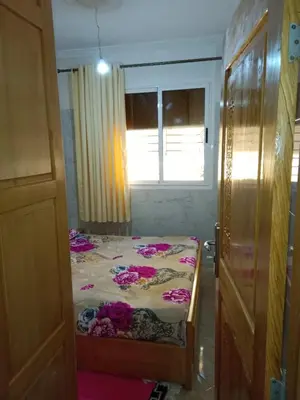 a bedroom with a bed with pink flowers on it at Appartement Hamza in Azrou