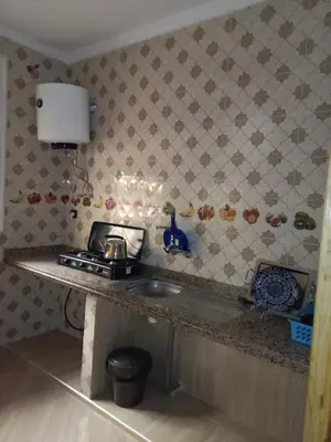 a kitchen with a counter top with a stove and a sink at Appartement Hamza in Azrou