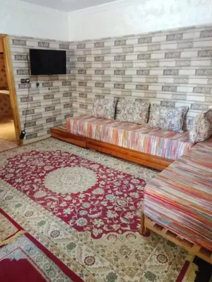 a living room with a couch and a brick wall at Appartement Hamza in Azrou