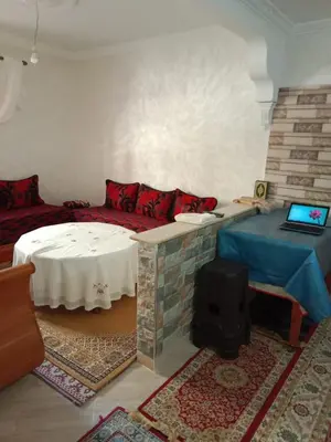 a living room with a couch and a table with a laptop at Appartement Hamza in Azrou