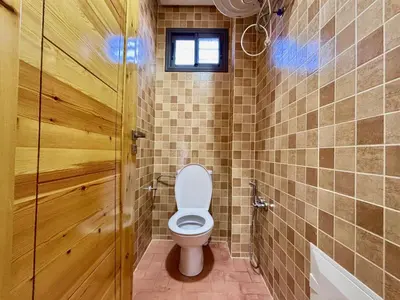 a bathroom with a toilet and a window and a door at Complexe Kariat Ayoub in Aït Zat