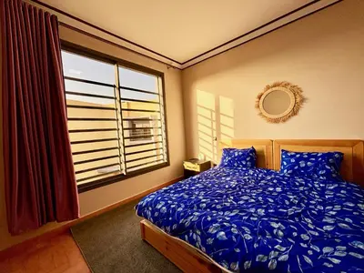 a bedroom with a bed and a large window at Complexe Kariat Ayoub in Aït Zat
