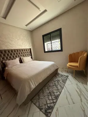 a bedroom with a large bed and a chair at Oasis deluxe in Fès