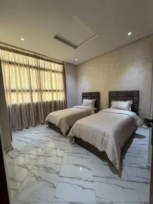 a bedroom with two beds with marble floors and a window at Oasis deluxe in Fès