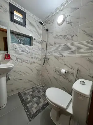 a white bathroom with a toilet and a sink at Oasis deluxe in Fès