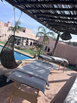 a hammock hanging from a pergola next to a pool at Hacienda Joud Marrakech-Safi in Ben Bouih
