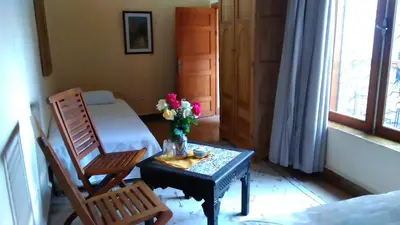 a room with a table with a vase of flowers on it at Dar Essoaoude - Fes Nejjarine in Fès