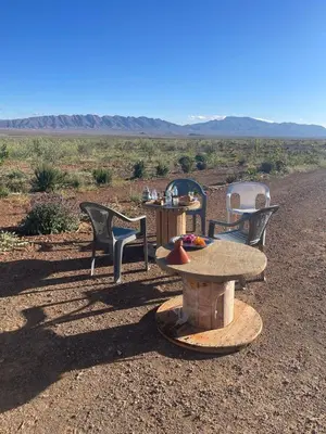 three chairs and a table in the middle of a field at Olecactus in Gourrama