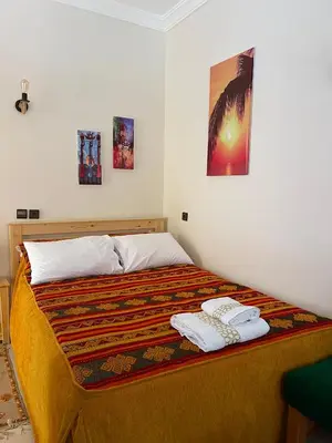 a bedroom with a bed with two towels on it at Dyafat Abla in Ouarzazate
