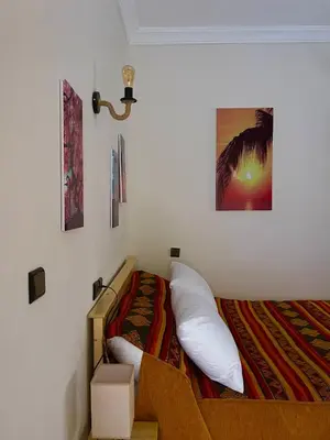 a bedroom with a bed and a picture on the wall at Dyafat Abla in Ouarzazate