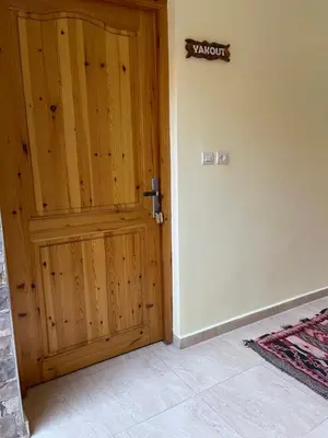 a wooden door with a sign on a wall at Dyafat Abla in Ouarzazate