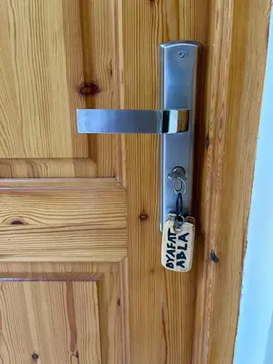 a lock on a wooden door with a key at Dyafat Abla in Ouarzazate