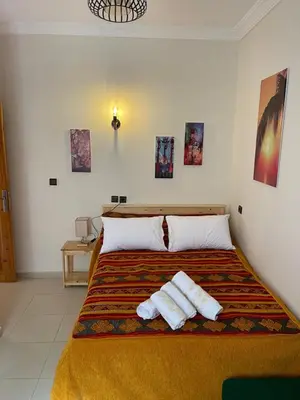 a bedroom with a bed with two towels on it at Dyafat Abla in Ouarzazate