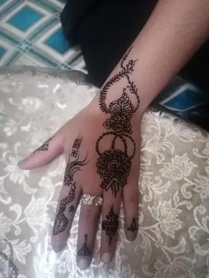 a woman with a henna design on her hand at Dar lmallouki in Meknès