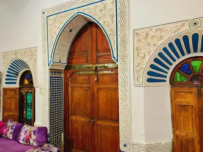 a room with two large wooden doors in a building at Dar lmallouki in Meknès