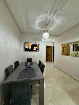 a dining room with a table and black chairs at Appartement de luxe in Fès