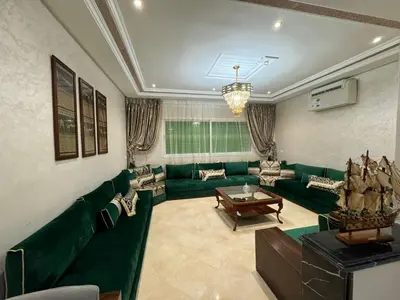 a living room with a green couch and a table at Appartement de luxe in Fès