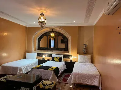 a room with two beds and a mirror at Riad Ritaj in Meknès