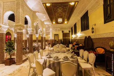 a banquet hall with tables and chairs in a building at Riad Ritaj in Meknès