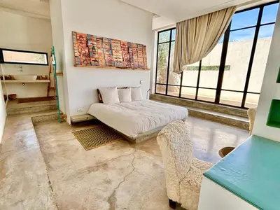 a bedroom with a bed and a couch and windows at Palais Akbal in Marrakech