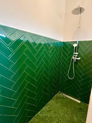 a bathroom with a green tiled wall with a shower at Palais Akbal in Marrakech