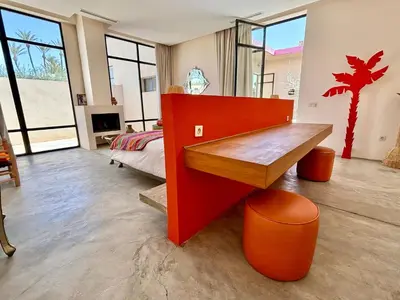 a living room with a red bench and a bedroom at Palais Akbal in Marrakech