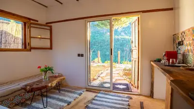 a living room with a large window and a table at Studio Azur in Bine el Ouidane