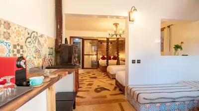 a room with two beds and a kitchen with a sink at Studio Azur in Bine el Ouidane
