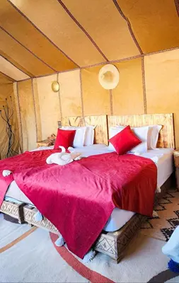 a bedroom with a large bed in a tent at Luxury Merzouga Desert Camp in Merzouga