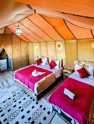 a bedroom with two beds in a tent at Luxury Merzouga Desert Camp in Merzouga