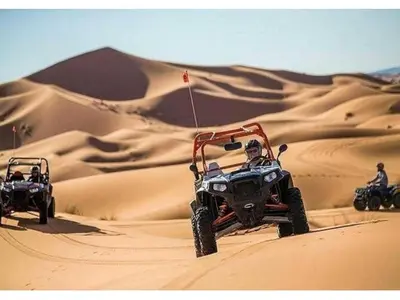 two people on atvs in the sand in the desert at Awesome Luxury Camp in Merzouga
