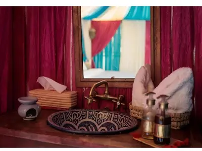 a bathroom counter with a sink and a mirror at Awesome Luxury Camp in Merzouga