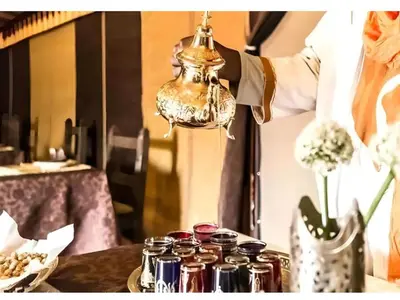 a person holding a bell over a table with jars at Awesome Luxury Camp in Merzouga