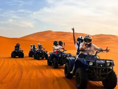 a group of people riding on atvs in the desert at Awesome Luxury Camp in Merzouga