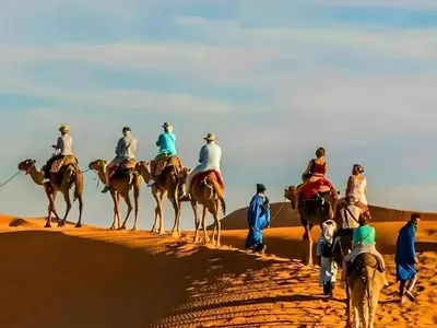 a group of people riding horses in the desert at Awesome Luxury Camp in Merzouga