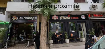 a restaurant with people sitting at tables outside of it at Appartement centre-ville avec Wifi fibre optique in Fès