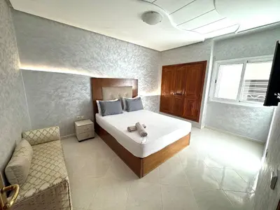 a bedroom with a bed and a couch in it at Appartement centre-ville avec Wifi fibre optique in Fès