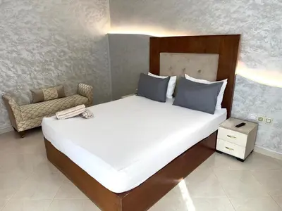 a bedroom with a large white bed with blue pillows at Appartement centre-ville avec Wifi fibre optique in Fès
