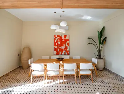 a dining room with a wooden table and white chairs at Palais Aureola Luxury Padel and Home Cinema in NʼChaba