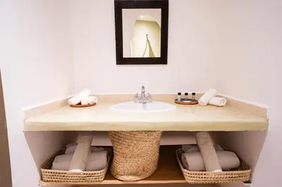 a bathroom with a sink and baskets under it at Palais Aureola Luxury Padel and Home Cinema in NʼChaba