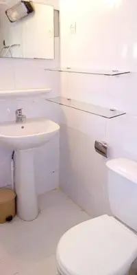 a white bathroom with a toilet and a sink at Chalet Authentique Au Centre-Ville in Ifrane