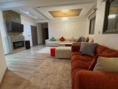 a living room with two couches and a television at حدائق افران in Ifrane