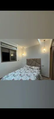 a bedroom with a bed and two lights and a window at حدائق افران in Ifrane