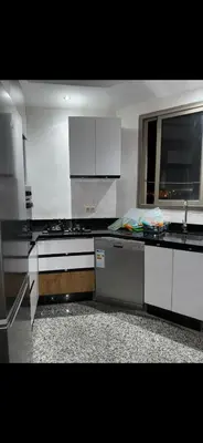 a kitchen with black and white counters and a sink at حدائق افران in Ifrane