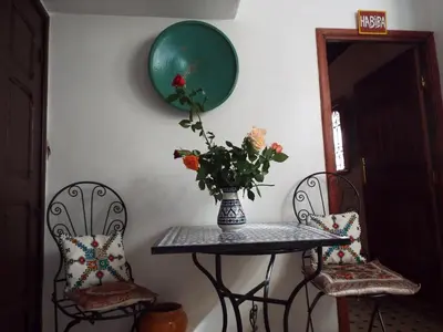 a table and two chairs with a vase of flowers on it at Dar Fès Huda in Fès