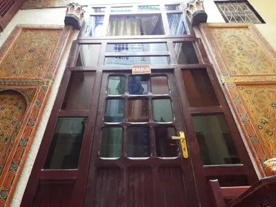a wooden door of a building with a sign on it at Dar Fès Huda in Fès