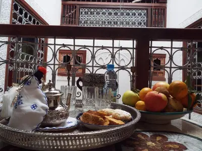 a table with a bowl of fruit and a plate of food at Dar Fès Huda in Fès